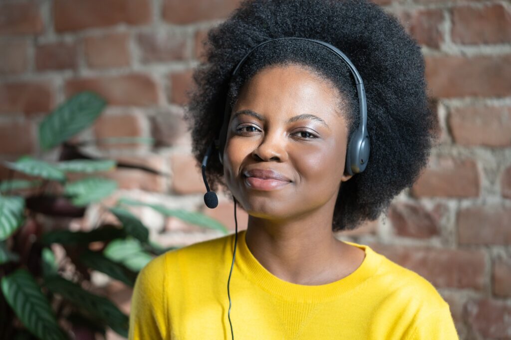 Smiling support phone operator in headset from home, online job, looking at camera. Call centre.